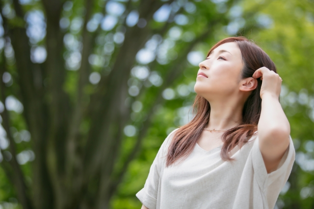 髪をかきあげる女性の画像